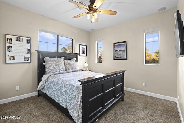 bedroom with ceiling fan, dark carpet, and baseboards