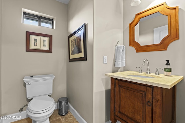 bathroom with toilet, baseboards, and vanity