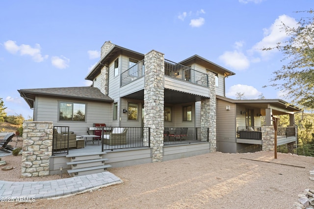 view of front of home featuring a balcony and a chimney