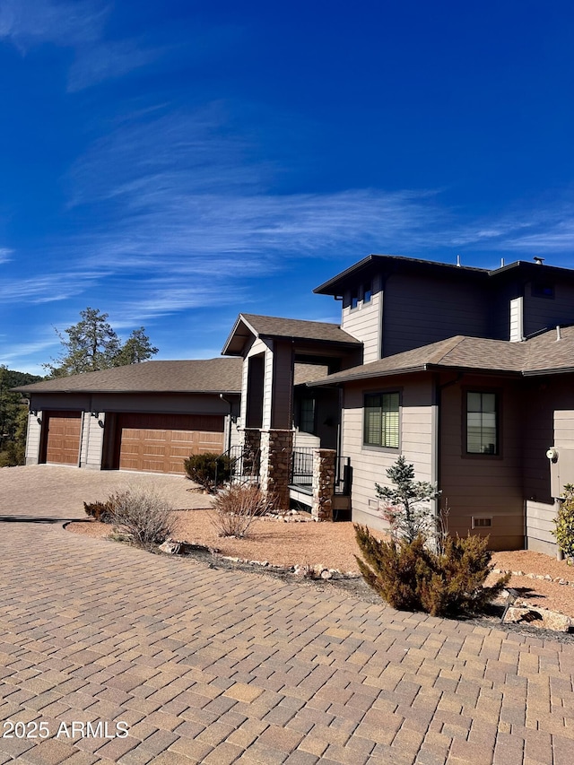 view of home's exterior with decorative driveway, crawl space, and an attached garage