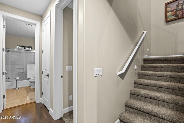 stairway featuring wood finished floors and baseboards