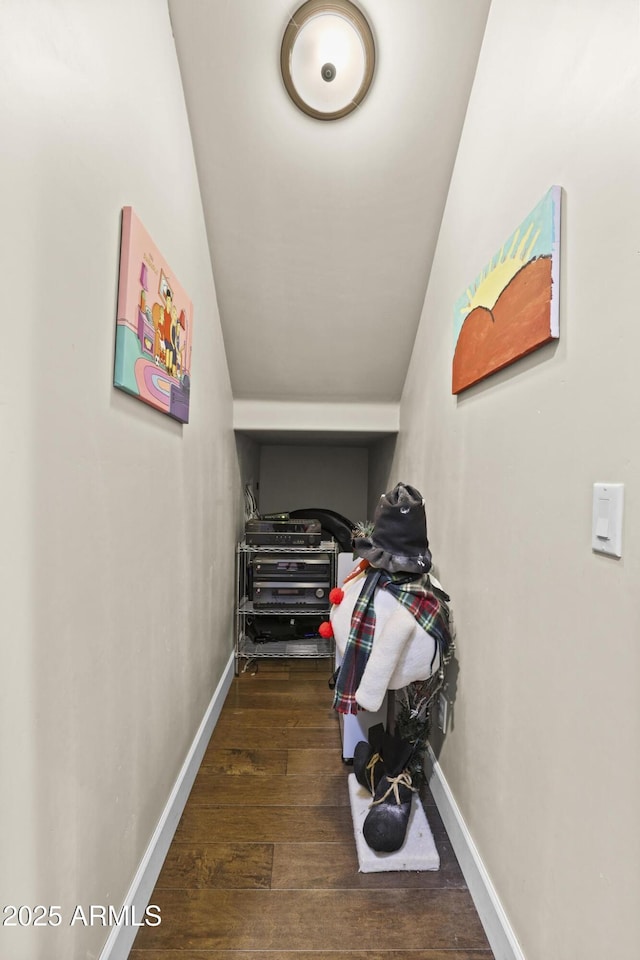 corridor with dark wood-type flooring and baseboards