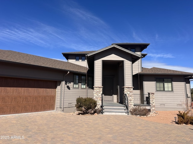 prairie-style home with an attached garage, crawl space, decorative driveway, and roof with shingles