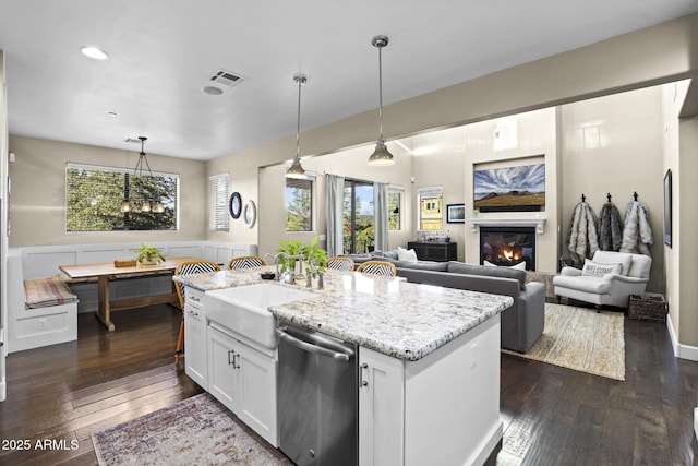 kitchen featuring visible vents, white cabinets, breakfast area, hanging light fixtures, and stainless steel dishwasher