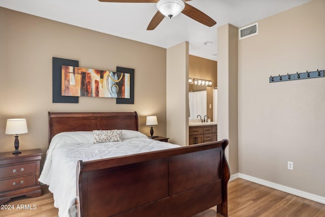 bedroom featuring ensuite bath, hardwood / wood-style flooring, sink, and ceiling fan