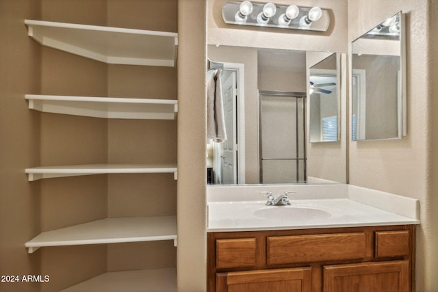 bathroom featuring vanity, walk in shower, and ceiling fan