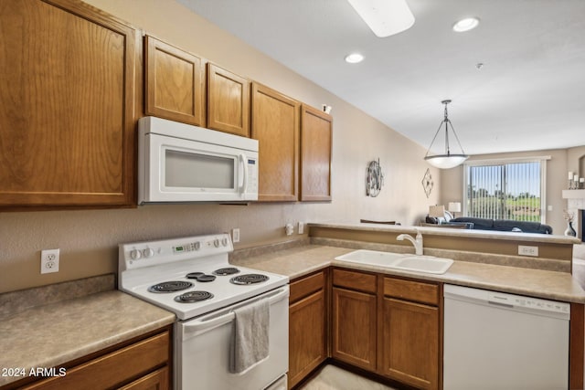 kitchen with sink, hanging light fixtures, and white appliances