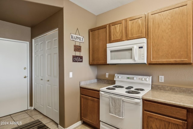 kitchen with white appliances and light tile patterned flooring