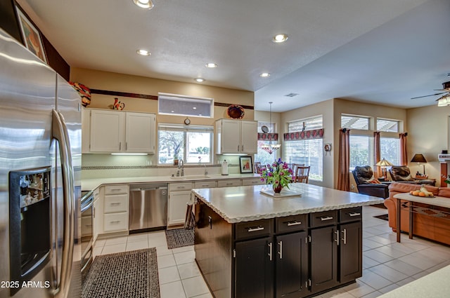 kitchen with light tile patterned floors, stainless steel appliances, decorative backsplash, pendant lighting, and white cabinets