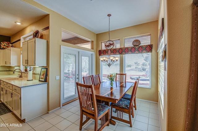 tiled dining area featuring a chandelier, french doors, and sink