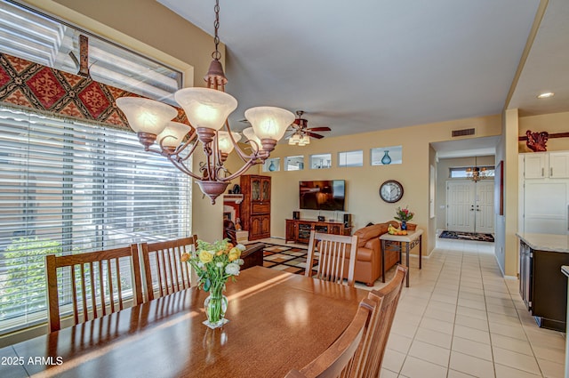 dining area with ceiling fan with notable chandelier and light tile patterned floors