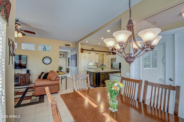 dining room with light tile patterned floors and ceiling fan with notable chandelier