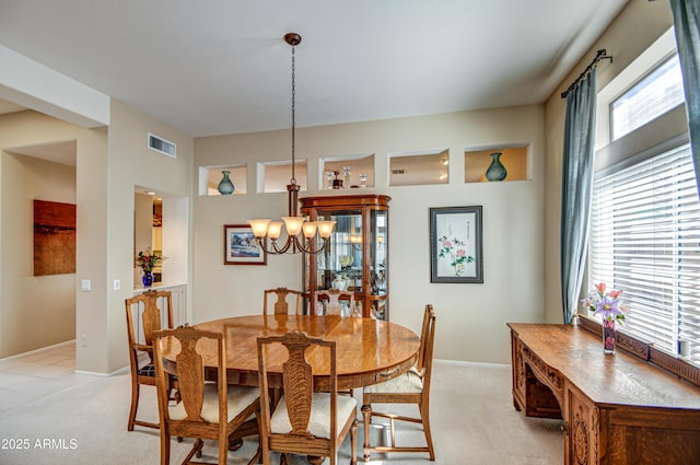 dining space featuring light colored carpet and a chandelier