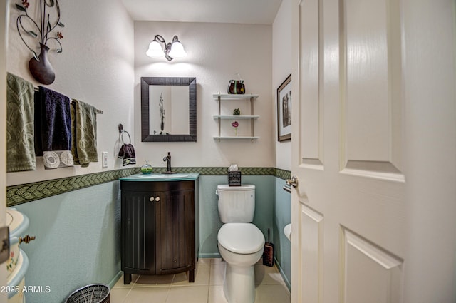 bathroom featuring toilet, tile patterned flooring, and vanity