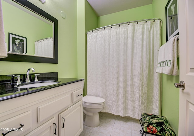 bathroom with toilet, vanity, and tile patterned floors