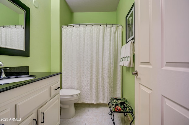 bathroom featuring toilet, tile patterned floors, and vanity