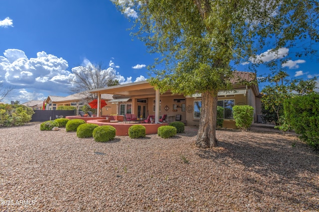 rear view of property with ceiling fan and a patio