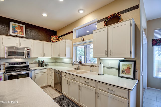 kitchen featuring sink, white cabinets, stainless steel appliances, and light tile patterned flooring