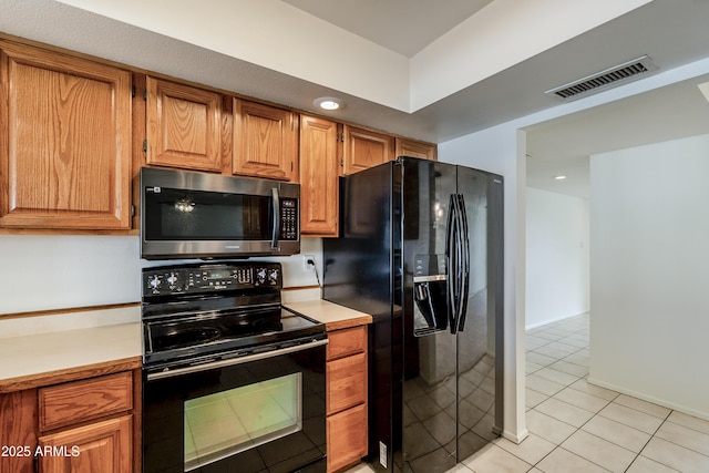 kitchen featuring light tile patterned flooring and black appliances