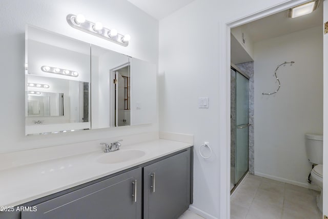 bathroom featuring tile patterned flooring, vanity, toilet, and a shower with shower door