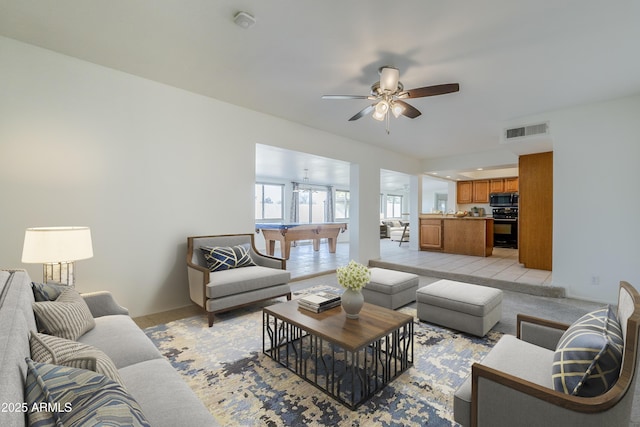 living room featuring light tile patterned floors, ceiling fan, and pool table