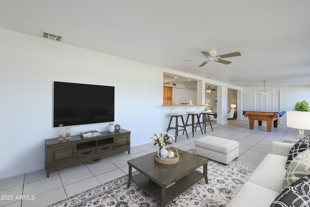 living room featuring light tile patterned floors, ceiling fan, and pool table