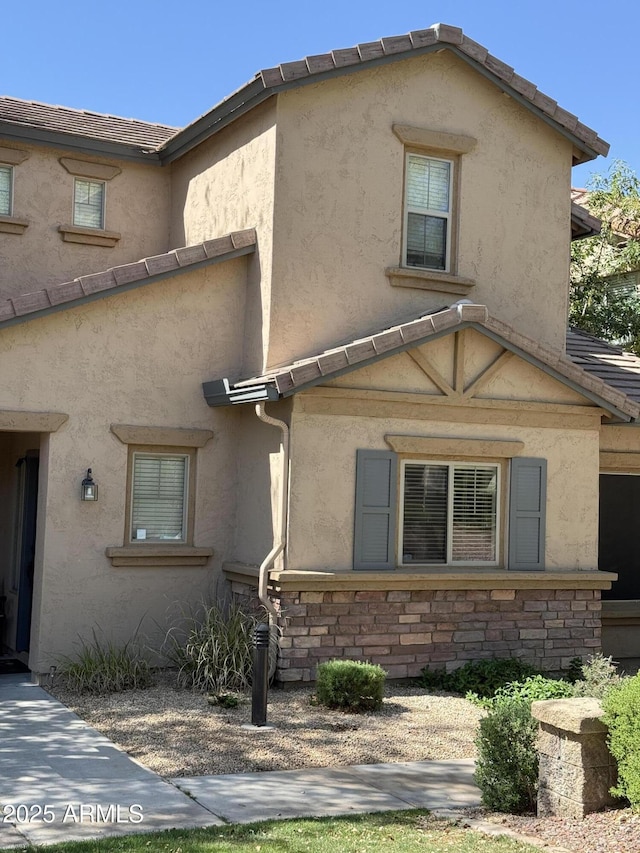 view of home's exterior featuring stucco siding and stone siding