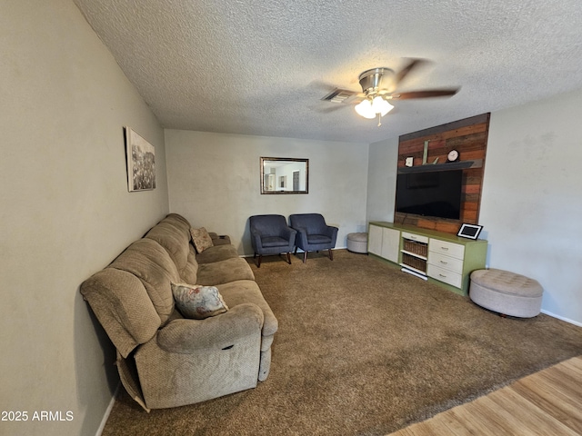 living area with wood finished floors, a ceiling fan, a textured ceiling, and visible vents