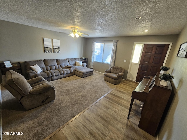 living room with a ceiling fan, a textured ceiling, and wood finished floors