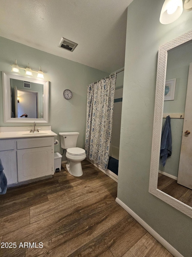 full bathroom featuring visible vents, wood finished floors, vanity, toilet, and a shower with shower curtain