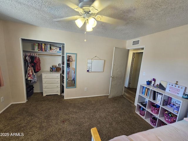 bedroom featuring visible vents, a closet, dark colored carpet, a textured ceiling, and a ceiling fan