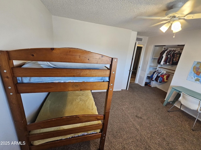 bedroom with a textured ceiling, visible vents, ceiling fan, and carpet