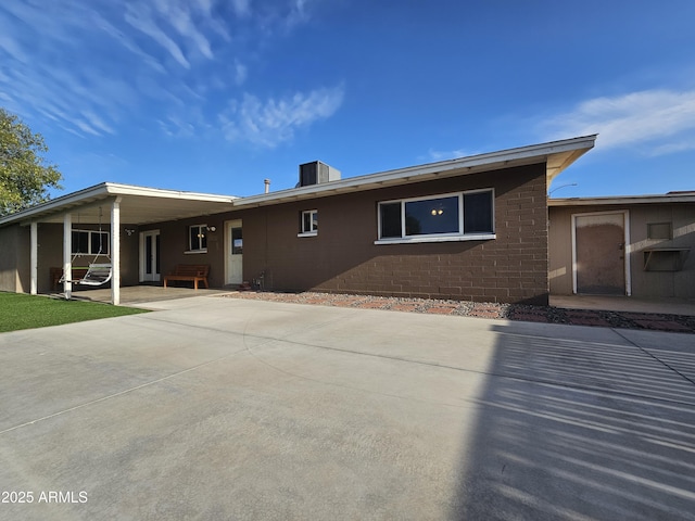 view of front facade featuring a patio, concrete driveway, and an attached carport