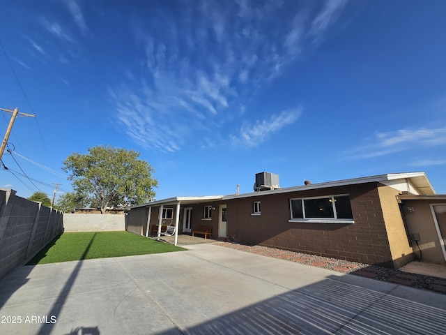back of house with a fenced backyard, a lawn, a patio, and cooling unit