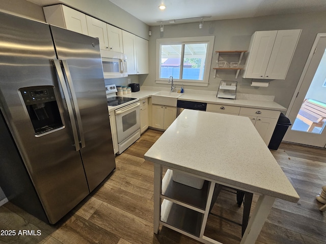 kitchen with dark wood-style flooring, stainless steel appliances, white cabinets, and a sink