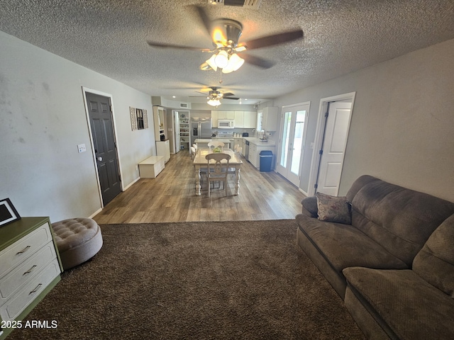 1904 E Jarvis Ave, Mesa, AZ 85204 - living room featuring a ceiling fan, light wood-type flooring, a textured ceiling, light colored carpet, and baseboards