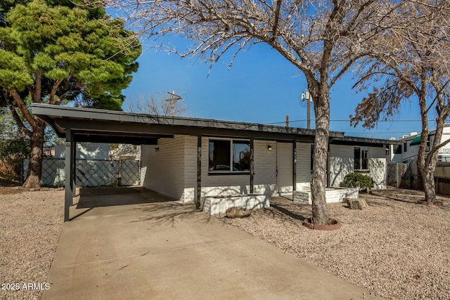 view of front of home featuring an attached carport, fence, and driveway