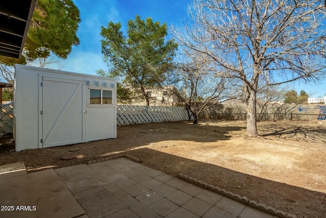 view of yard featuring a patio area, a fenced backyard, an outdoor structure, and a storage unit