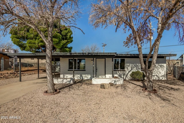 ranch-style house featuring driveway and fence