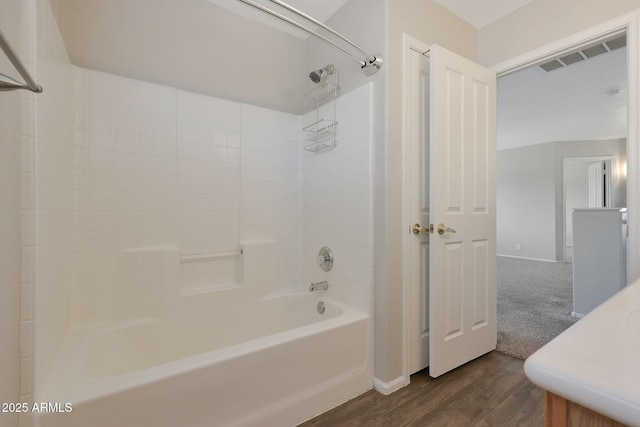 bathroom with hardwood / wood-style floors and shower / washtub combination