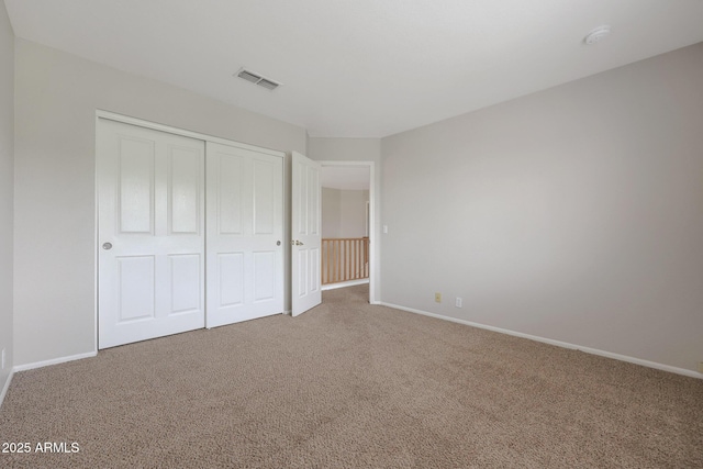 unfurnished bedroom with a closet and carpet flooring