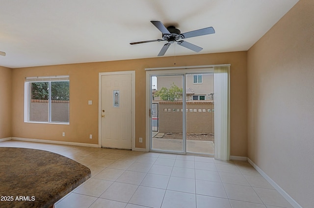 foyer with light tile patterned floors, baseboards, and a ceiling fan