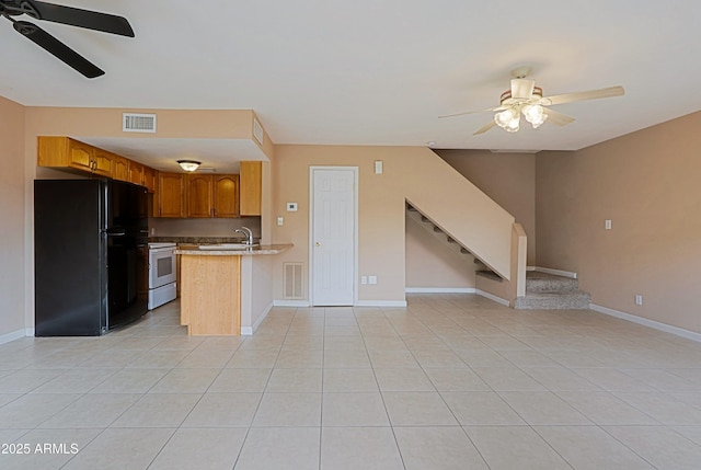 kitchen featuring white electric stove, visible vents, open floor plan, and freestanding refrigerator