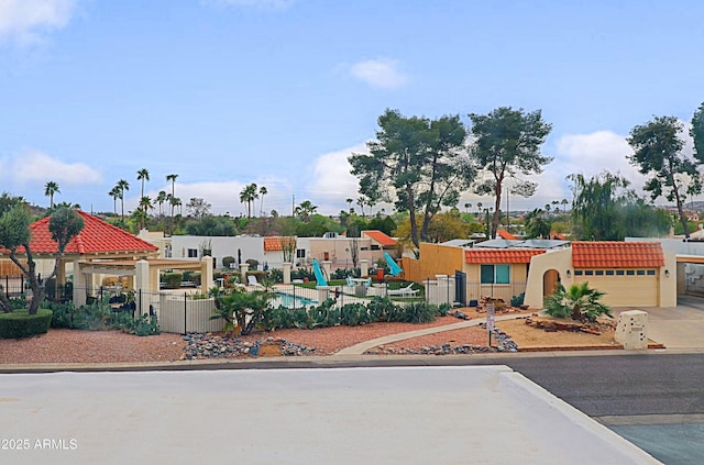 mediterranean / spanish-style home with a garage, concrete driveway, and fence