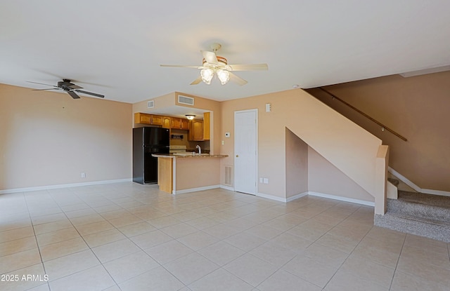 unfurnished living room with light tile patterned floors, a sink, visible vents, a ceiling fan, and stairs