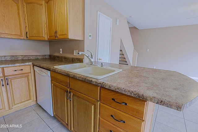 kitchen with white dishwasher, a sink, a peninsula, and light tile patterned floors