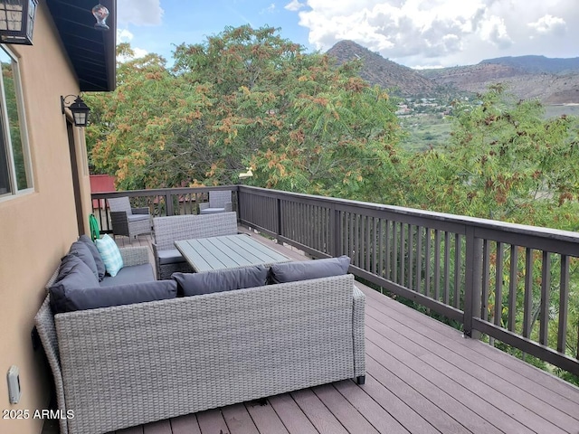 wooden terrace featuring a mountain view and an outdoor living space