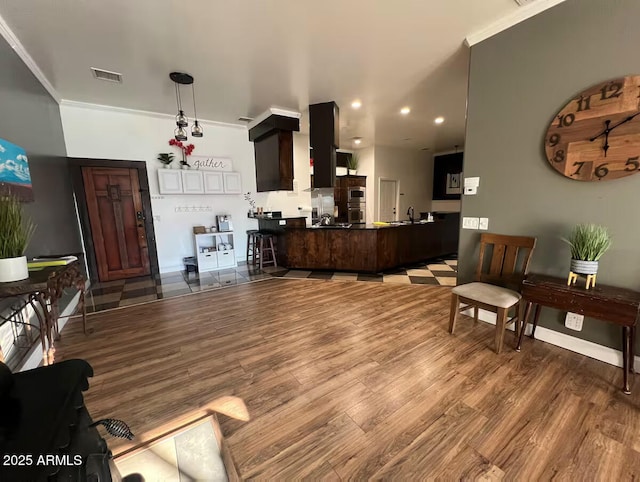 living room with recessed lighting, wood finished floors, visible vents, baseboards, and ornamental molding