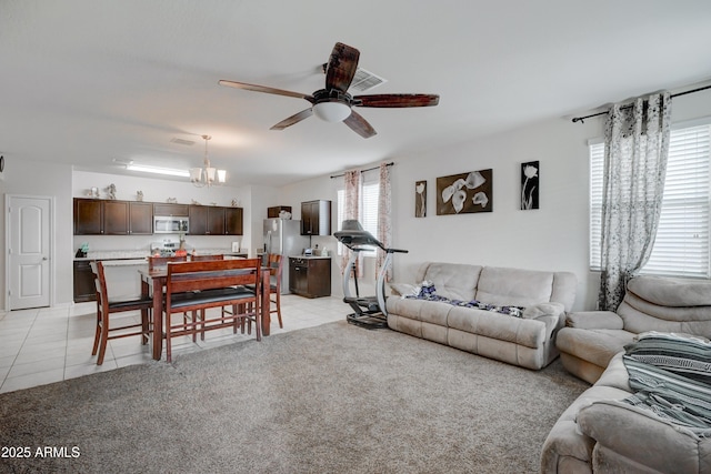 living room featuring light tile patterned flooring and ceiling fan with notable chandelier