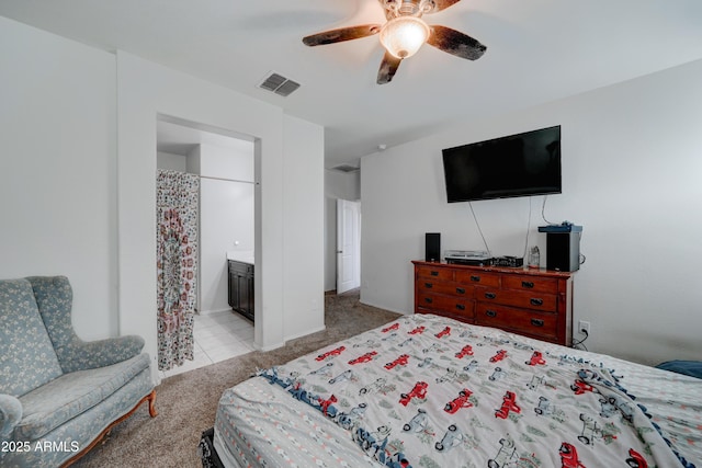 bedroom with light carpet, connected bathroom, and ceiling fan